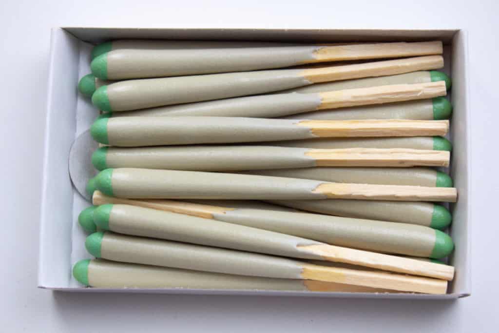 An open box of stormproof matches packed tip to tail, showing the wax coating on each stick